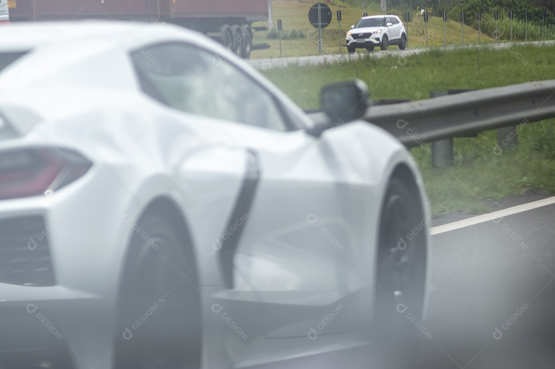 Carro de luxo Corvete passando em uma rodovia.