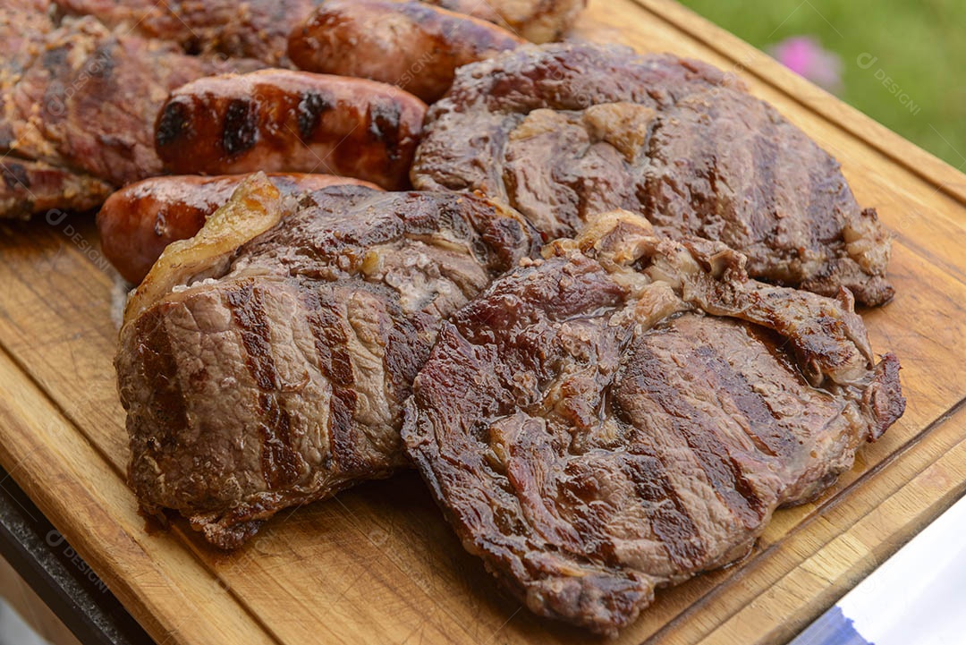 Churrasco brasileiro. Carnes assadas em uma tábua de madeira.
