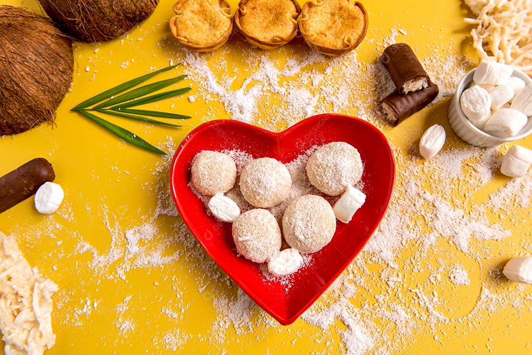 Doce de coco no fundo amarelo, cocada, coco ralado