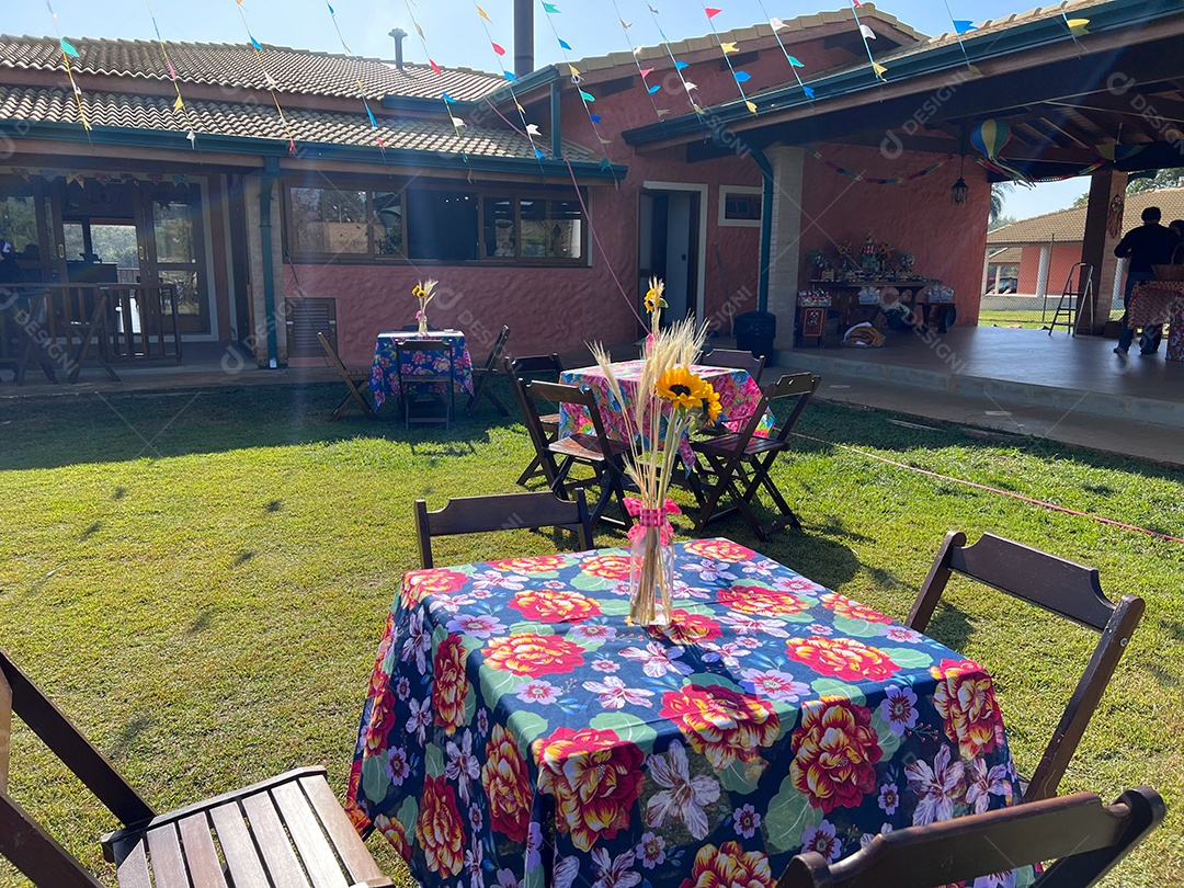 Decoração de Festa Junina, com flores, chapéus, carroça, feno e coração para tirar fotos.