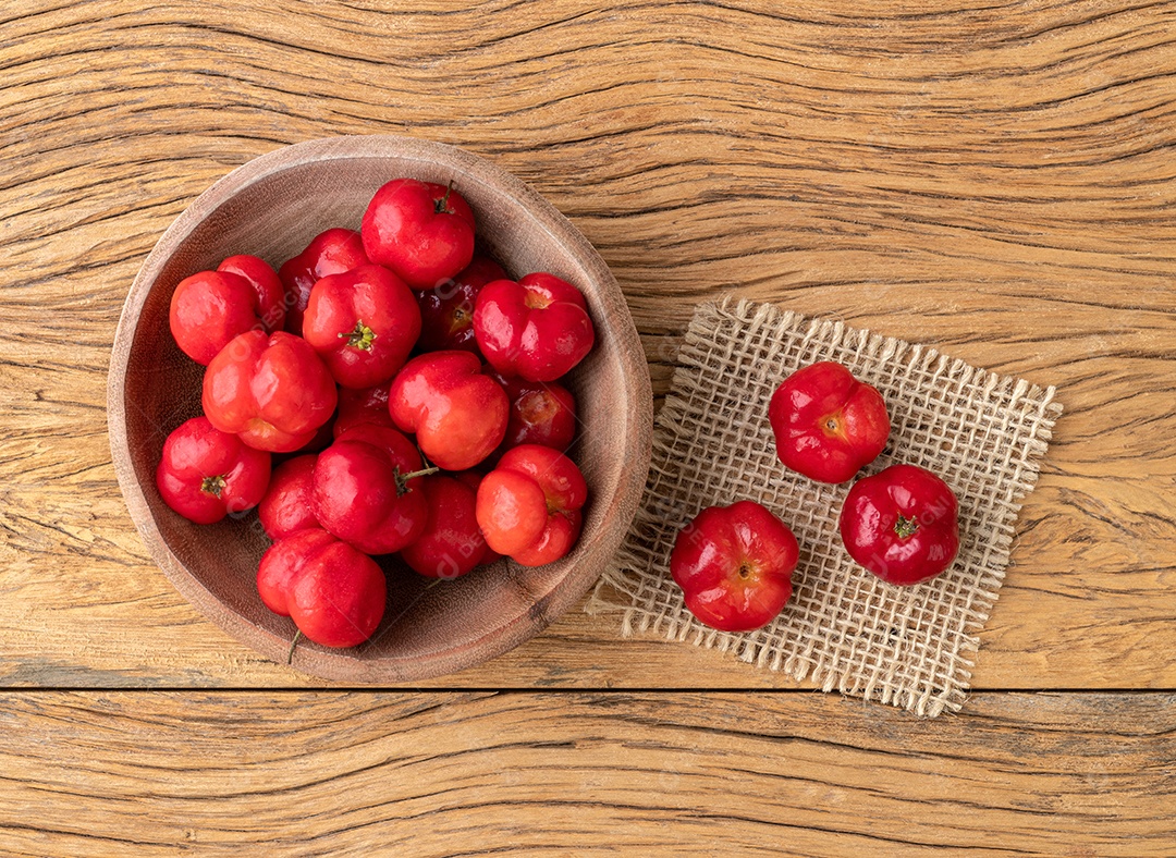 Acerolas ou cerejas de Barbados em uma tigela sobre a mesa de madeira