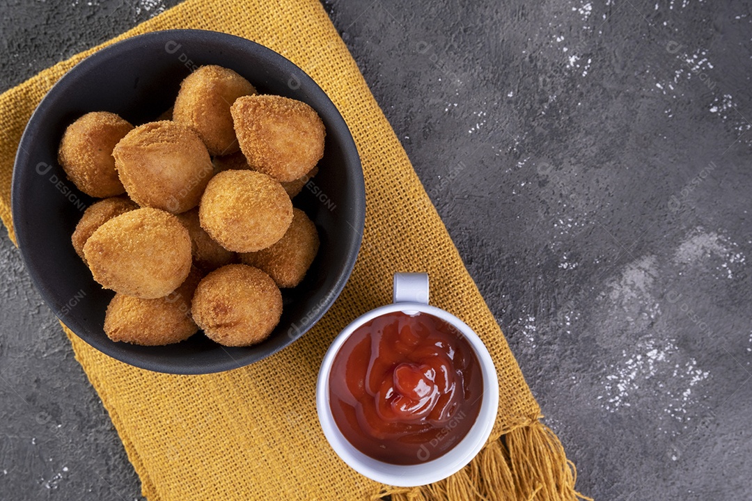 Tradicional petisco brasileiro frito recheado com frango e um copo de cerveja.
