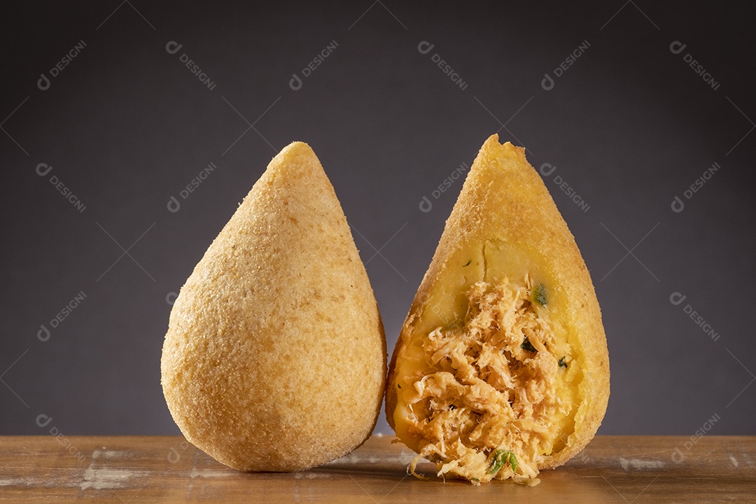 Coxinha frita na mesa de madeira com fundo gradiente marrom