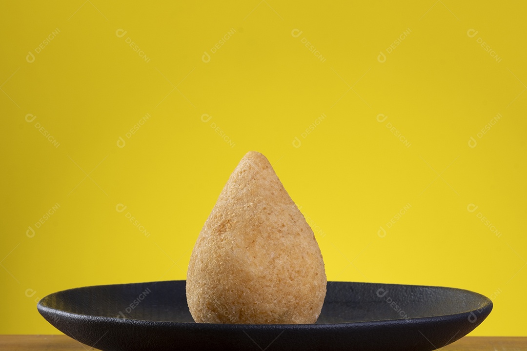 Coxinha na chapa preta com fundo amarelo