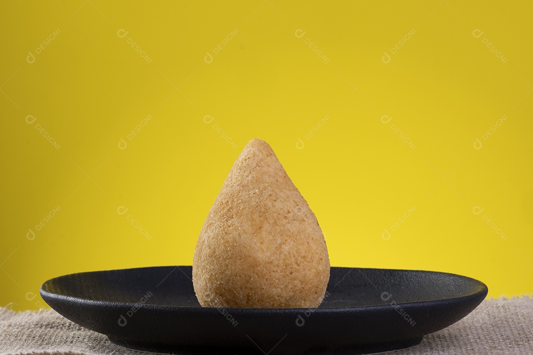 Coxinha na chapa preta com fundo amarelo