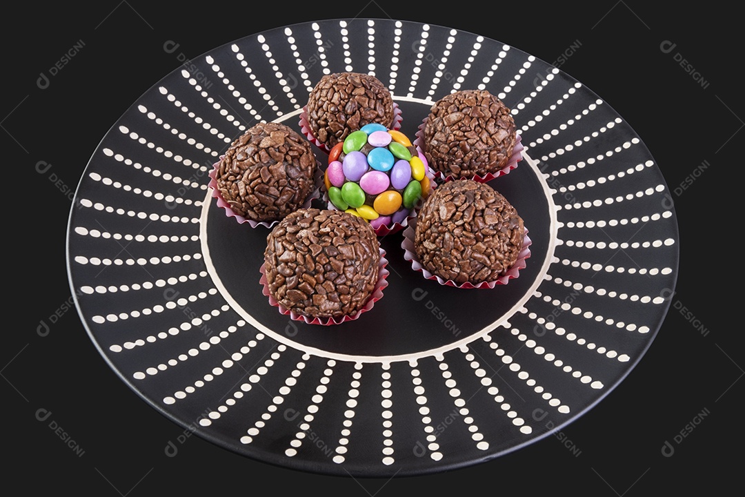 Brigadeiros em prato preto sobre fundo preto