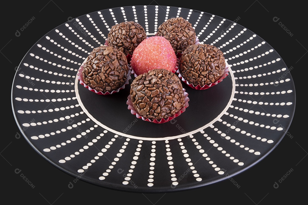 Brigadeiros em prato preto sobre fundo preto