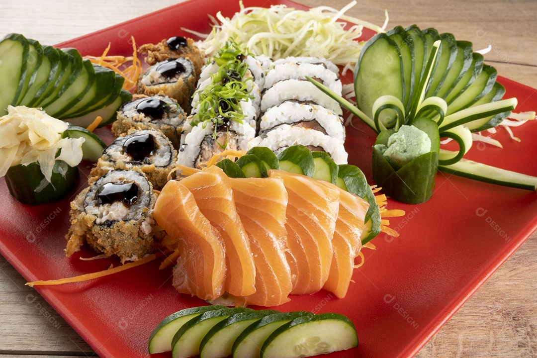 Rolo de sushi misto e sashimi de salmão no prato vermelho