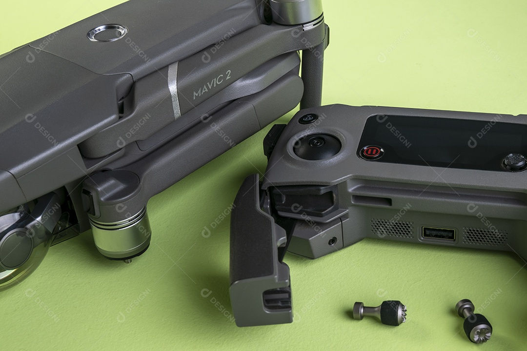 Drone DJI mavic 2 pro, seu controlador e um smartphone em fundo marrom.
