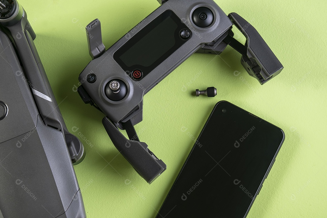 Drone DJI mavic 2 pro, seu controlador e um smartphone em fundo marrom.