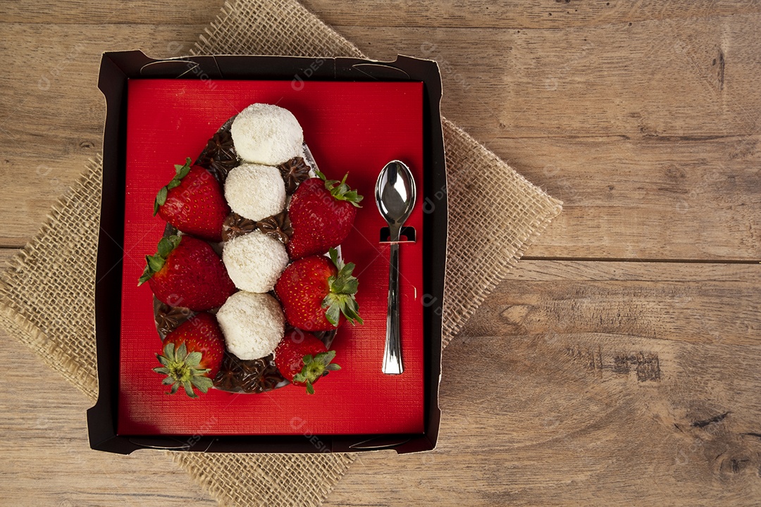 Caixa vermelha com meio ovo de páscoa, chocolates e morangos