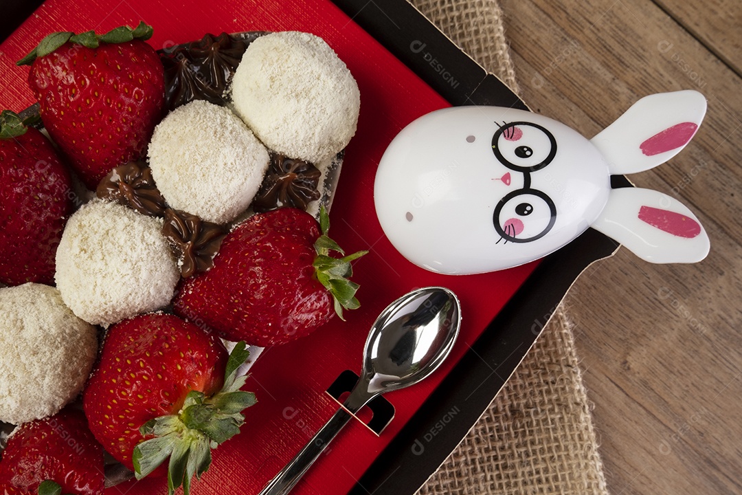 Caixa vermelha com meio ovo de páscoa, chocolates e morangos