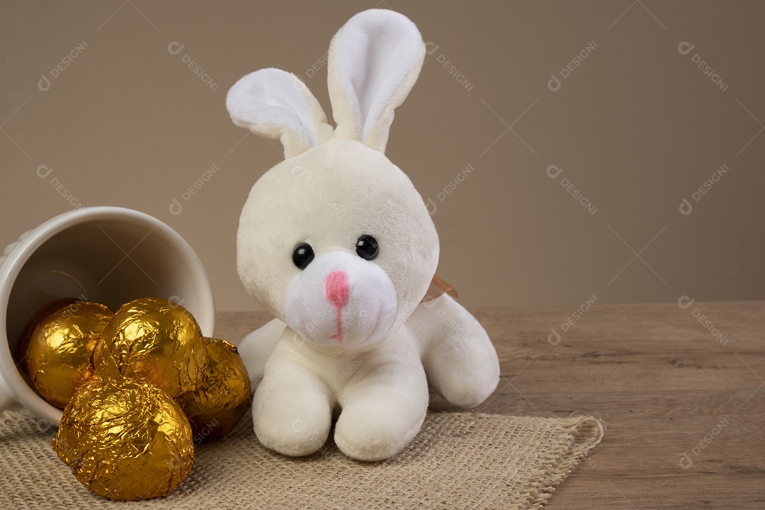 Trufas de chocolate embrulhadas em papel dourado ao lado de enfeites de Páscoa.