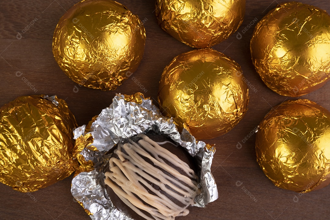 Trufas de chocolate embrulhadas em papel laminado em corte de madeira