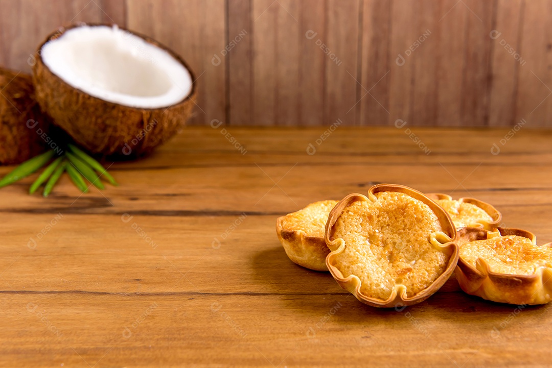 Coco e doce de coco (cocadinha) em fundo de madeira