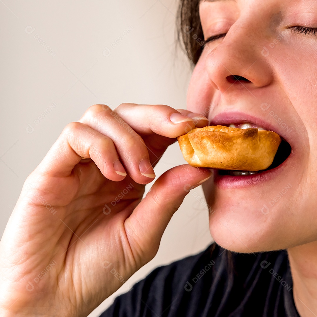 Mulher segurando doce de coco (beijinho)