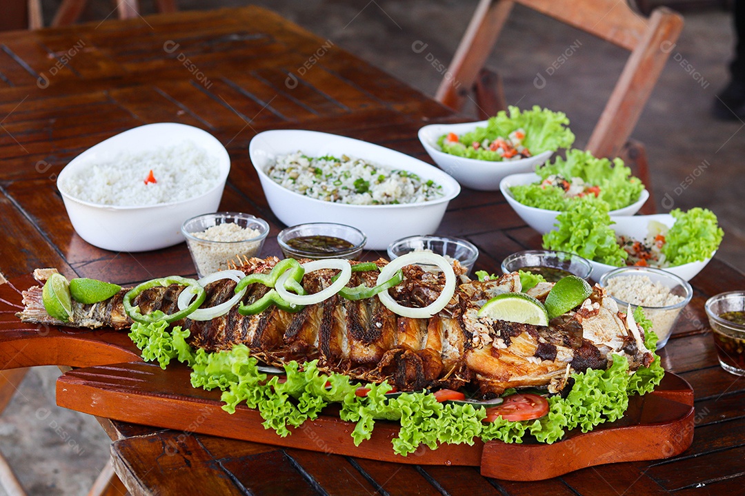 Filé de peixe acebolado sobre uma mesa de madeira