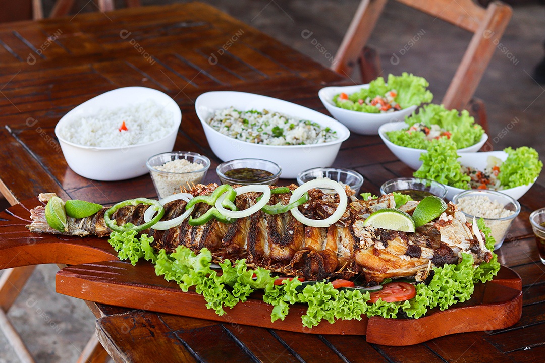 Filé de peixe acebolado sobre uma mesa de madeira