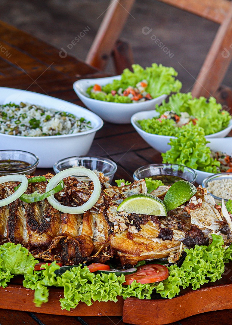 Filé de peixe acebolado sobre uma mesa de madeira