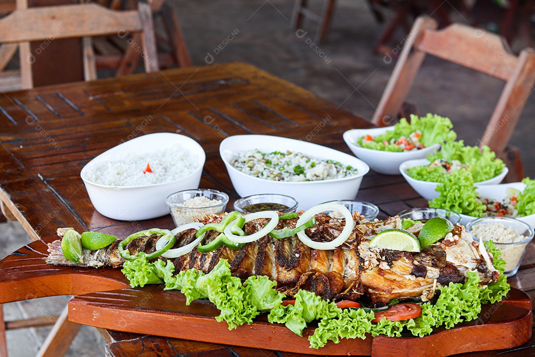 Filé de peixe acebolado sobre uma mesa de madeira