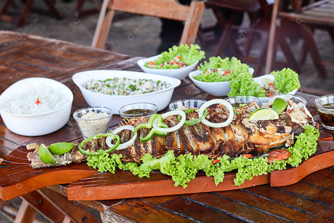 Filé de peixe acebolado sobre uma mesa de madeira