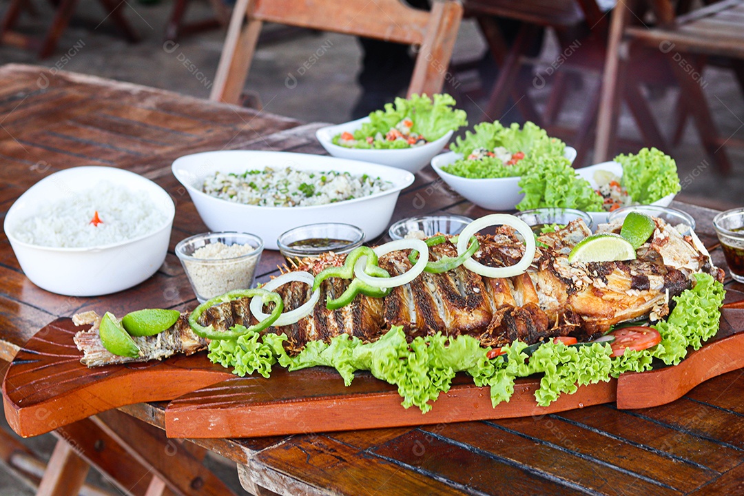 Filé de peixe acebolado sobre uma mesa de madeira