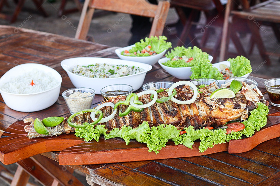 Filé de peixe acebolado sobre uma mesa de madeira