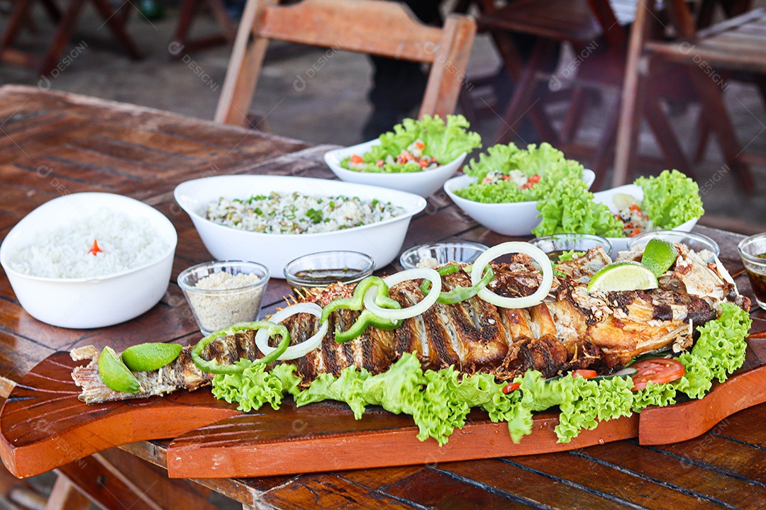 Filé de peixe acebolado sobre uma mesa de madeira