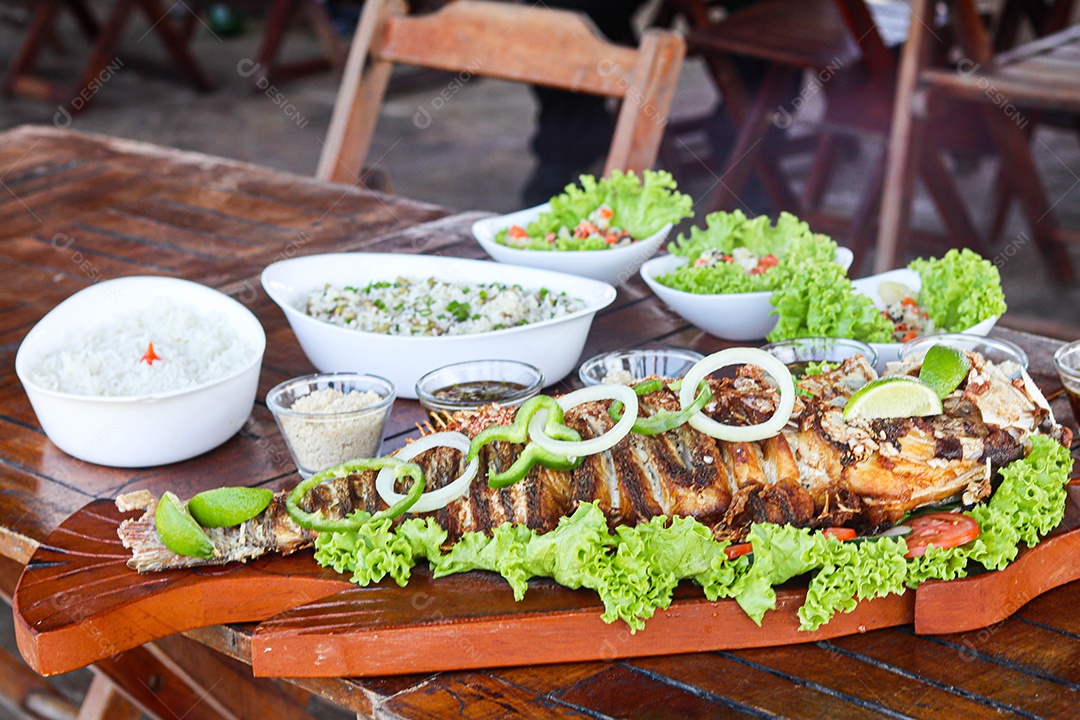 Filé de peixe acebolado sobre uma mesa de madeira