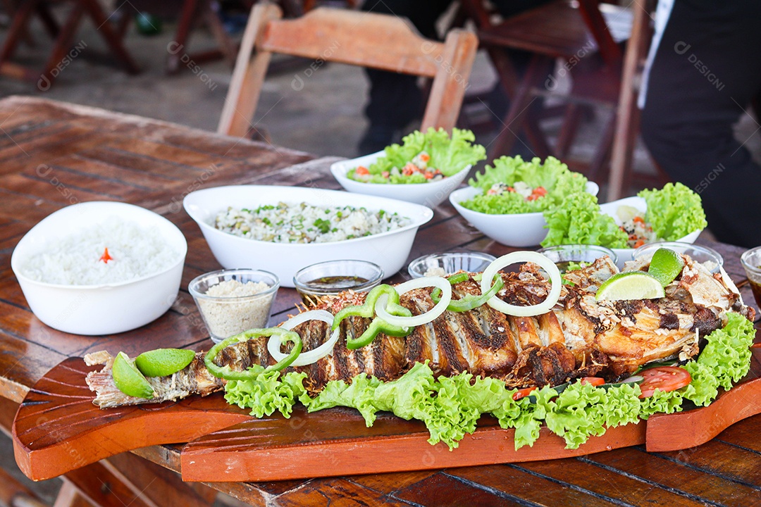 Filé de peixe acebolado sobre uma mesa de madeira