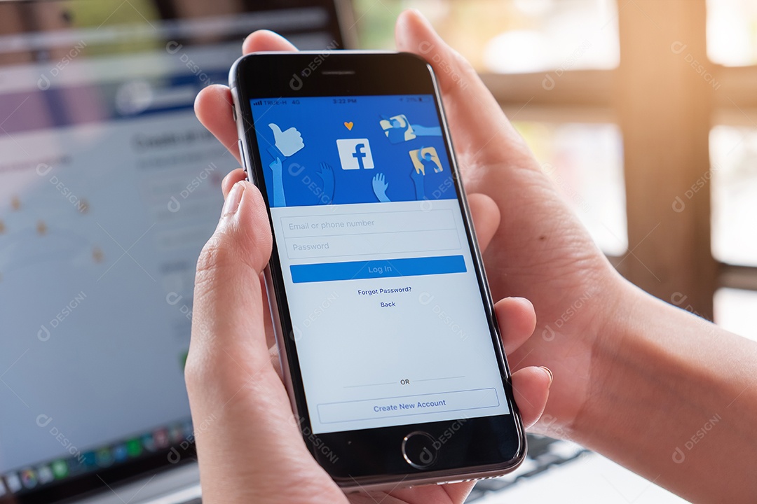 Uma mulher segura o Apple iPhone X com o aplicativo Facebook In na tela.