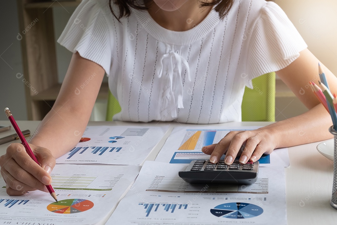 Empresária trabalhando na calculadora para calcular dados de negócios do relatório financeiro.