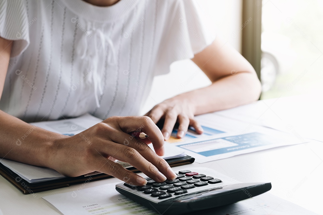 Empresária trabalhando na calculadora para calcular dados de negócios do relatório financeiro.