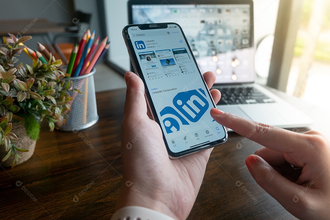 Mulher usando iPhone X com downloads de aplicativos do LinkedIn.