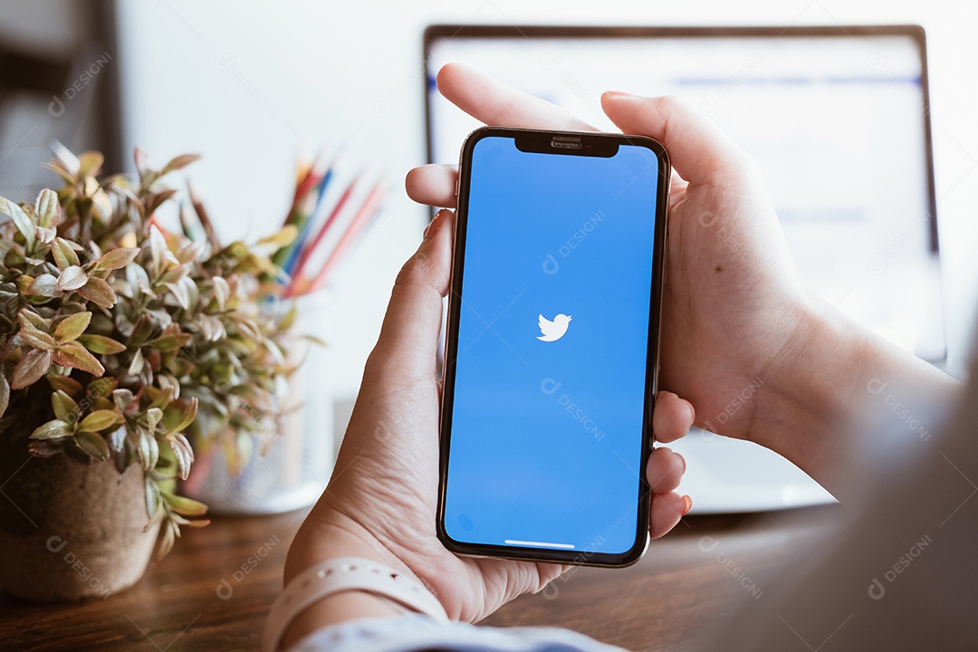 Pessoa segurando um novo Apple iPhone com o logotipo do Twitter na tela.