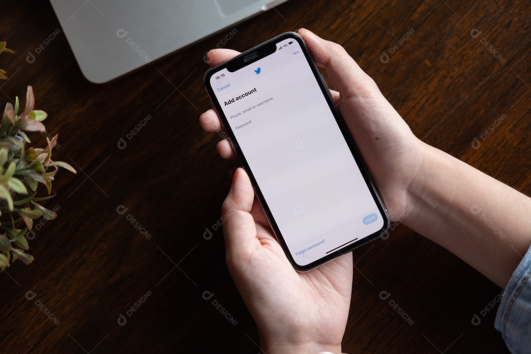Pessoa segurando um novo Apple iPhone com o logotipo do Twitter na tela.