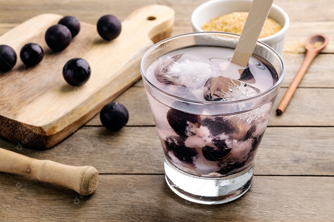 Caipirinha de jabuticaba brasileira em um copo com gelo e frutas