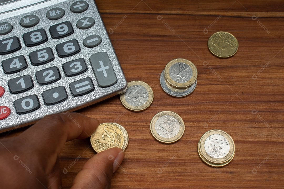 Dinheiro ao lado de calculadora sobre uma mesa