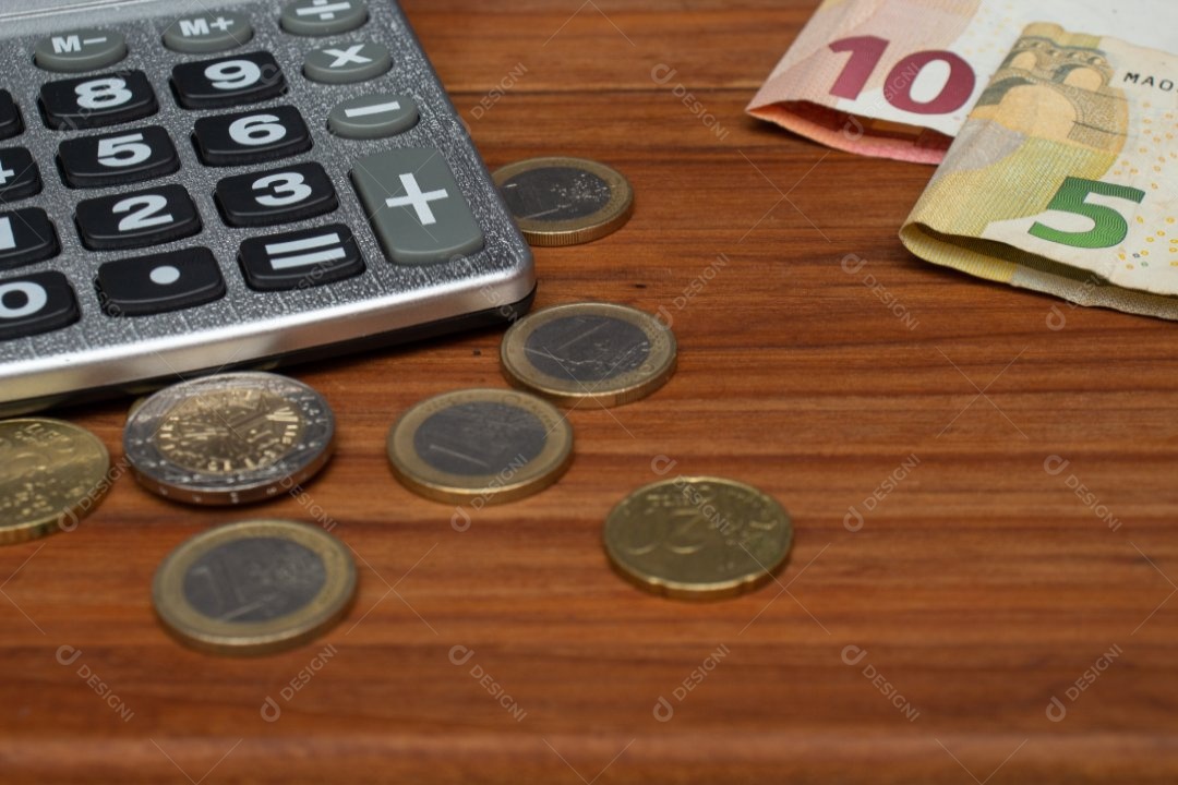 Dinheiro ao lado de calculadora sobre uma mesa
