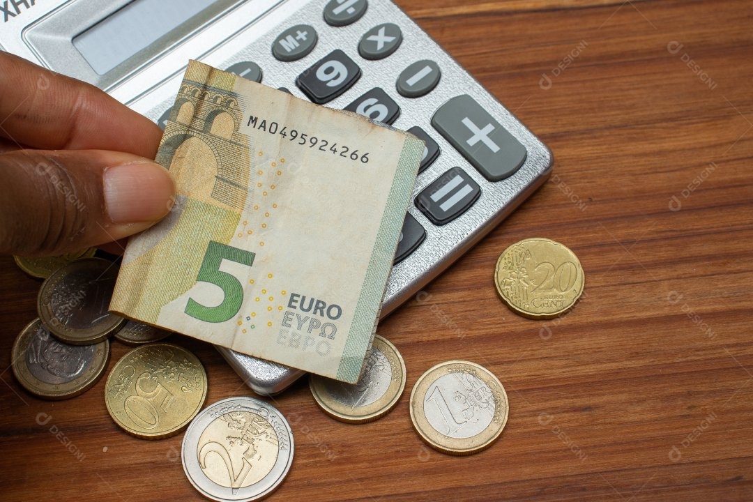 Dinheiro ao lado de calculadora sobre uma mesa