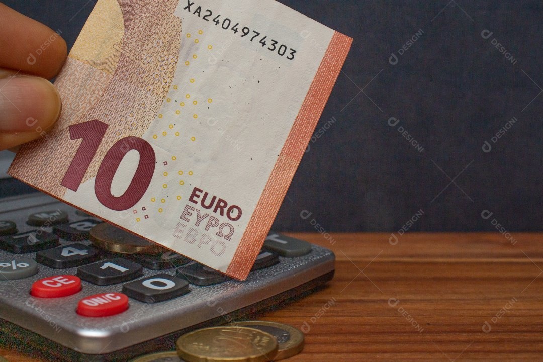 Dinheiro ao lado de calculadora sobre uma mesa