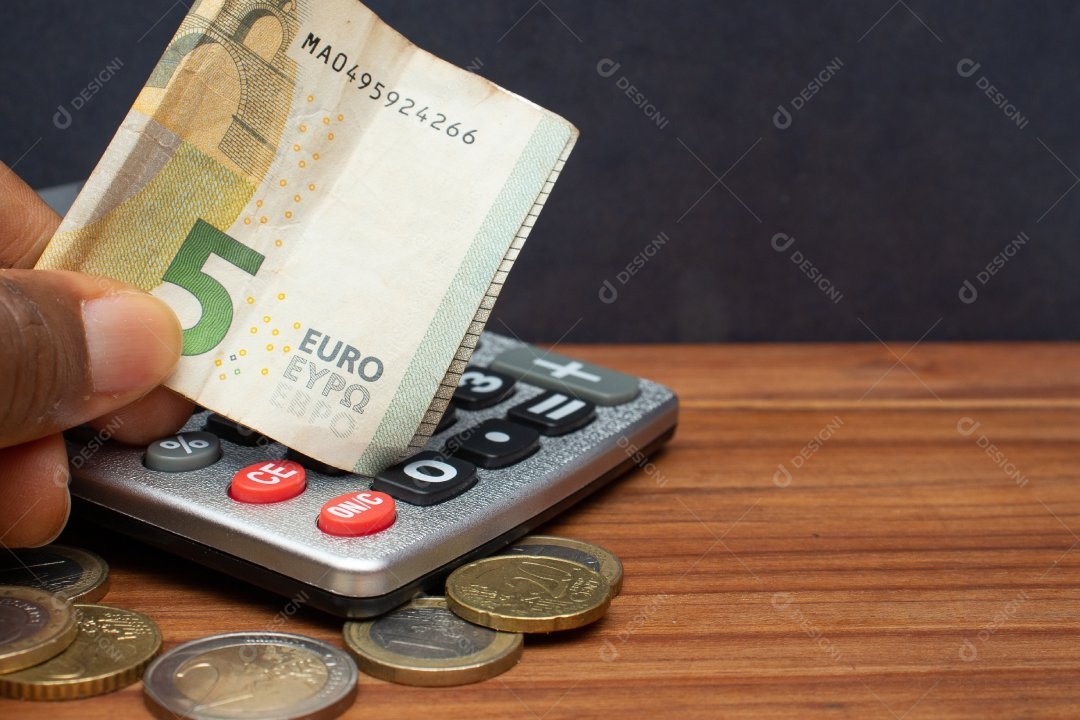 Dinheiro ao lado de calculadora sobre uma mesa