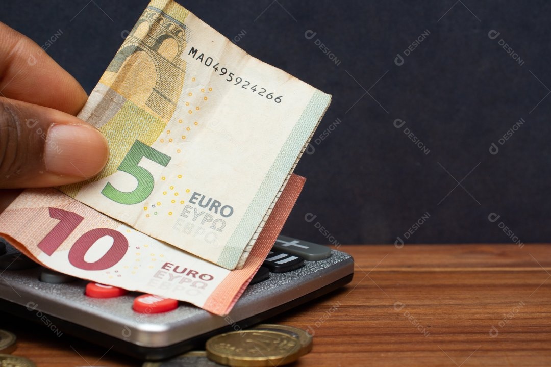 Dinheiro ao lado de calculadora sobre uma mesa