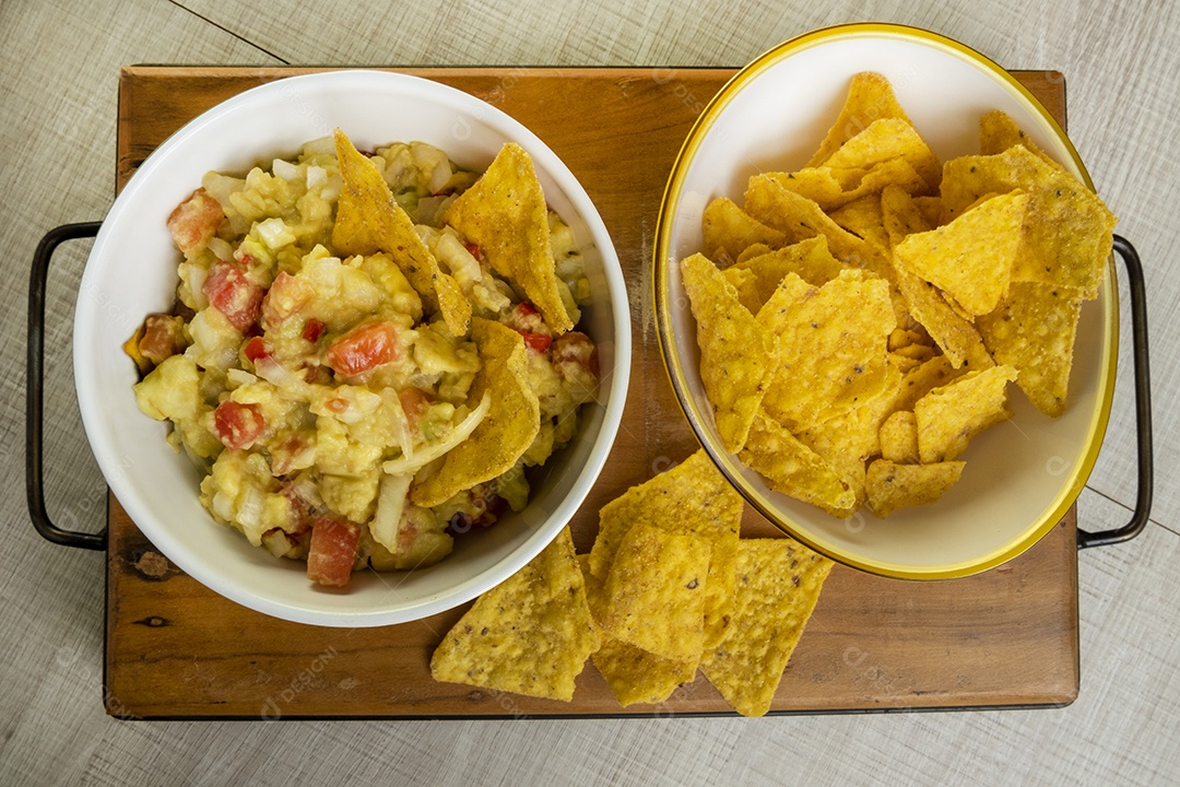 Guacamole com tortilhas na mesa de madeira