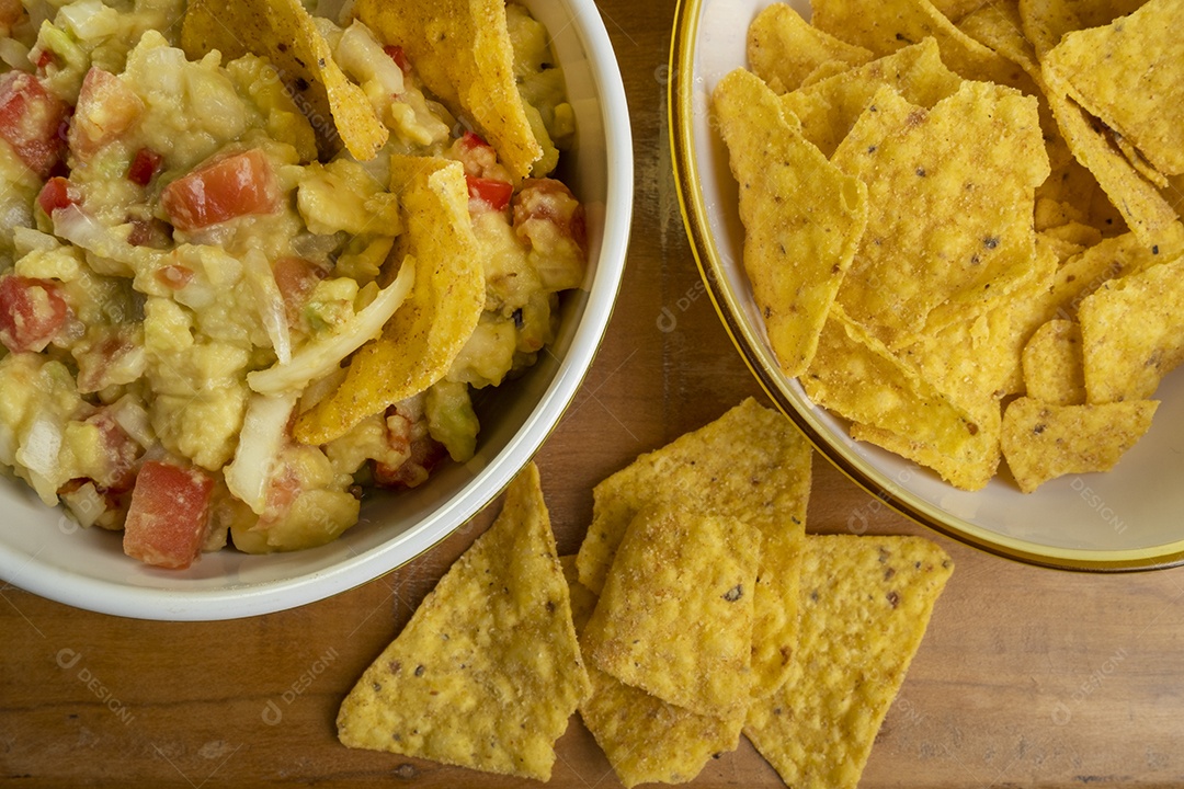 Guacamole com tortilhas na mesa de madeira