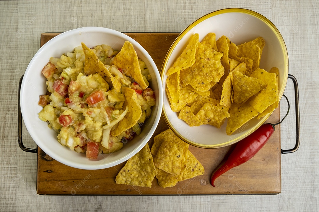 Guacamole com tortilhas na mesa de madeira