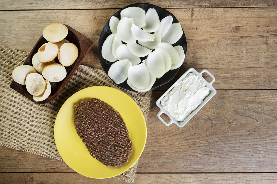 Quibe cru com cebola fatiada, requeijão seco, pão sírio e folha de hortelã