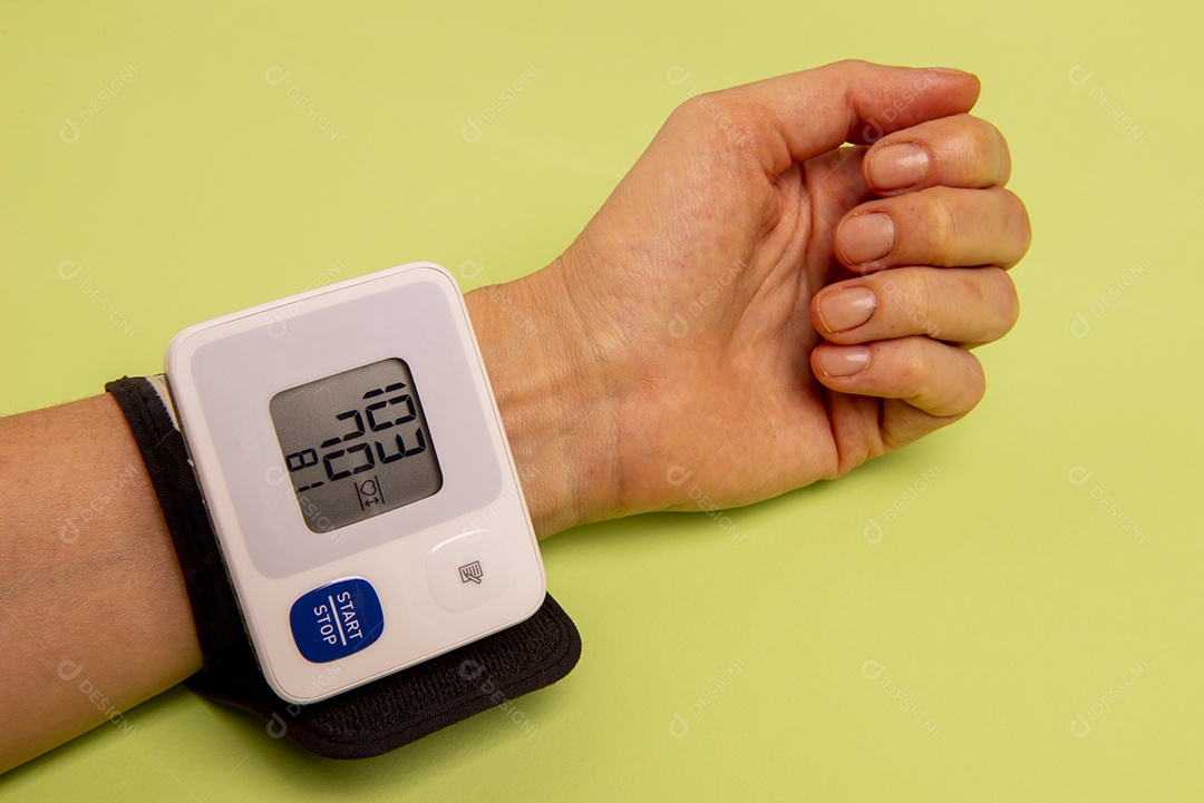 Mão de uma mulher medindo sua pressão arterial
