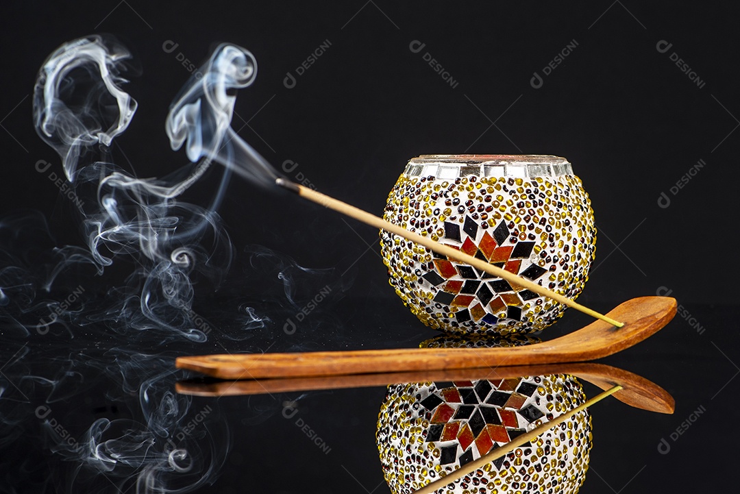 Porta-incenso de madeira e castiçal em fundo preto