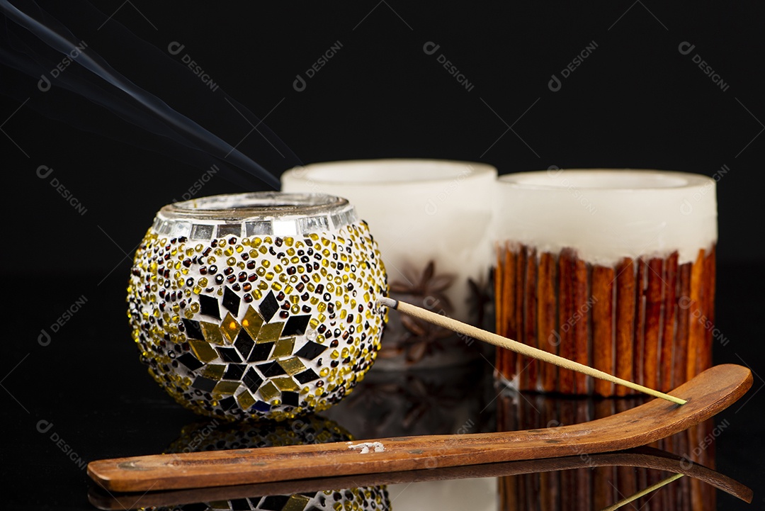 Suporte de incenso com algumas velas em fundo preto